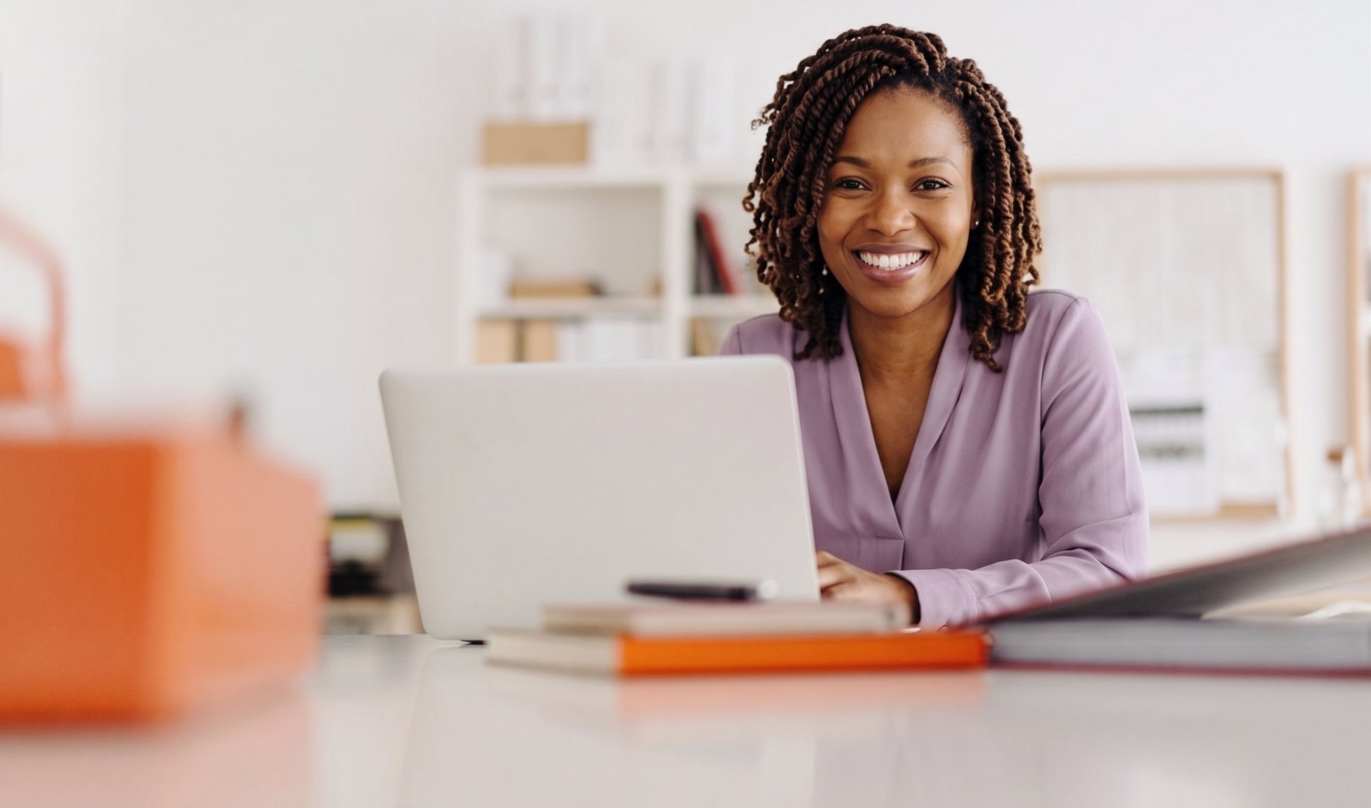 Patiente souriante reprenant son travail confortablement devant son ordinateur dès le lendemain de l'intervention